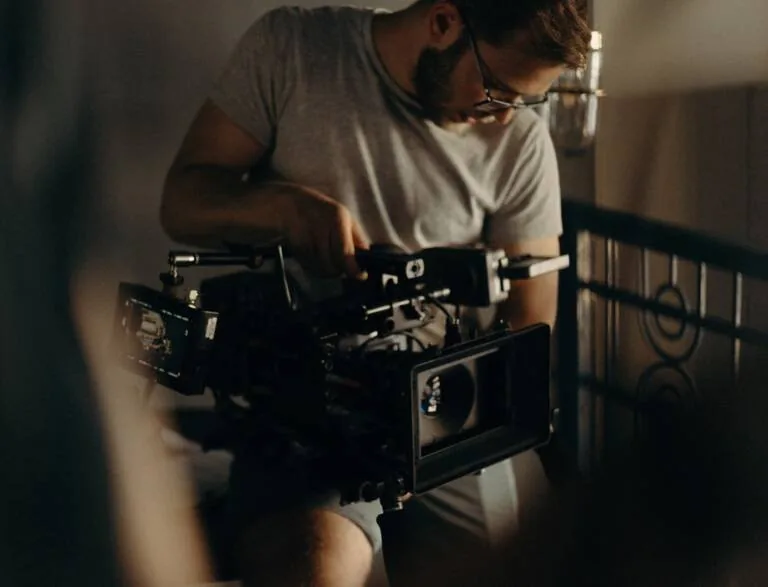 Camera operator adjusting a cinema camera on set